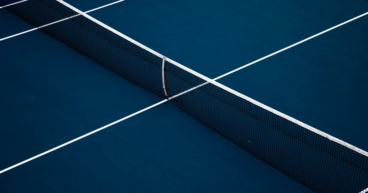 Filet et lignes d'un court de tennis bleu vus en plongée